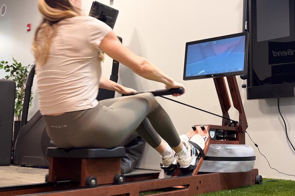 A woman sitting on an Ergatta Luxe Rower in the middle of a workout
