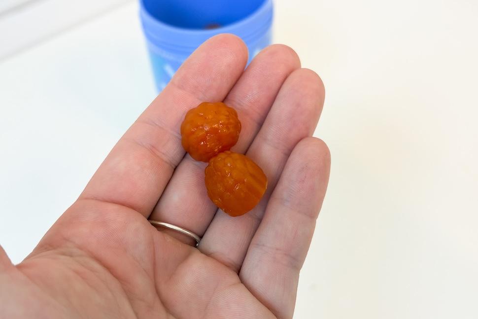 Closeup of an open palm holding two First Day Teens' Multi gummies
