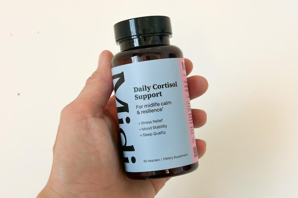 Closeup of a hand holding a bottle of Daily Cortisol Support
