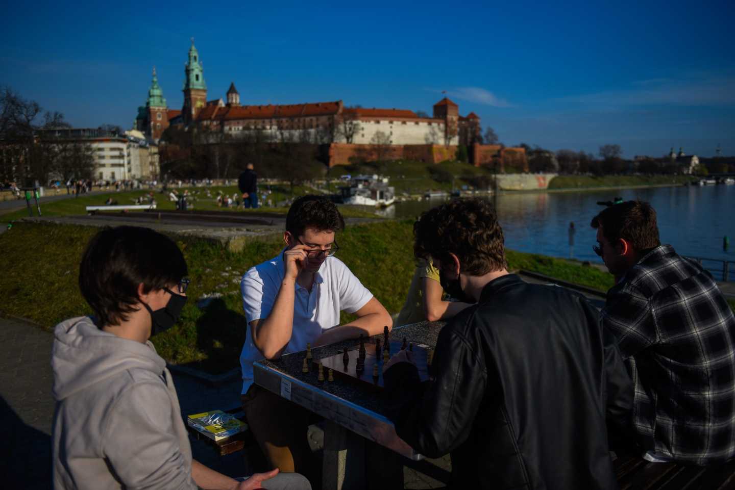 Photo of teenagers playing chess outside