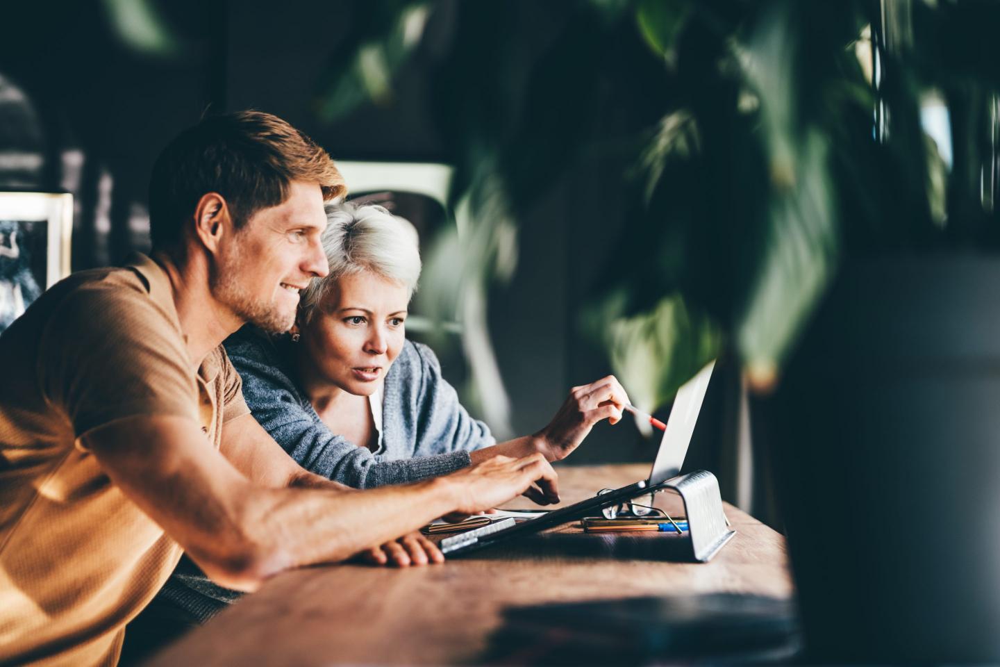 Two people working together on a laptop.