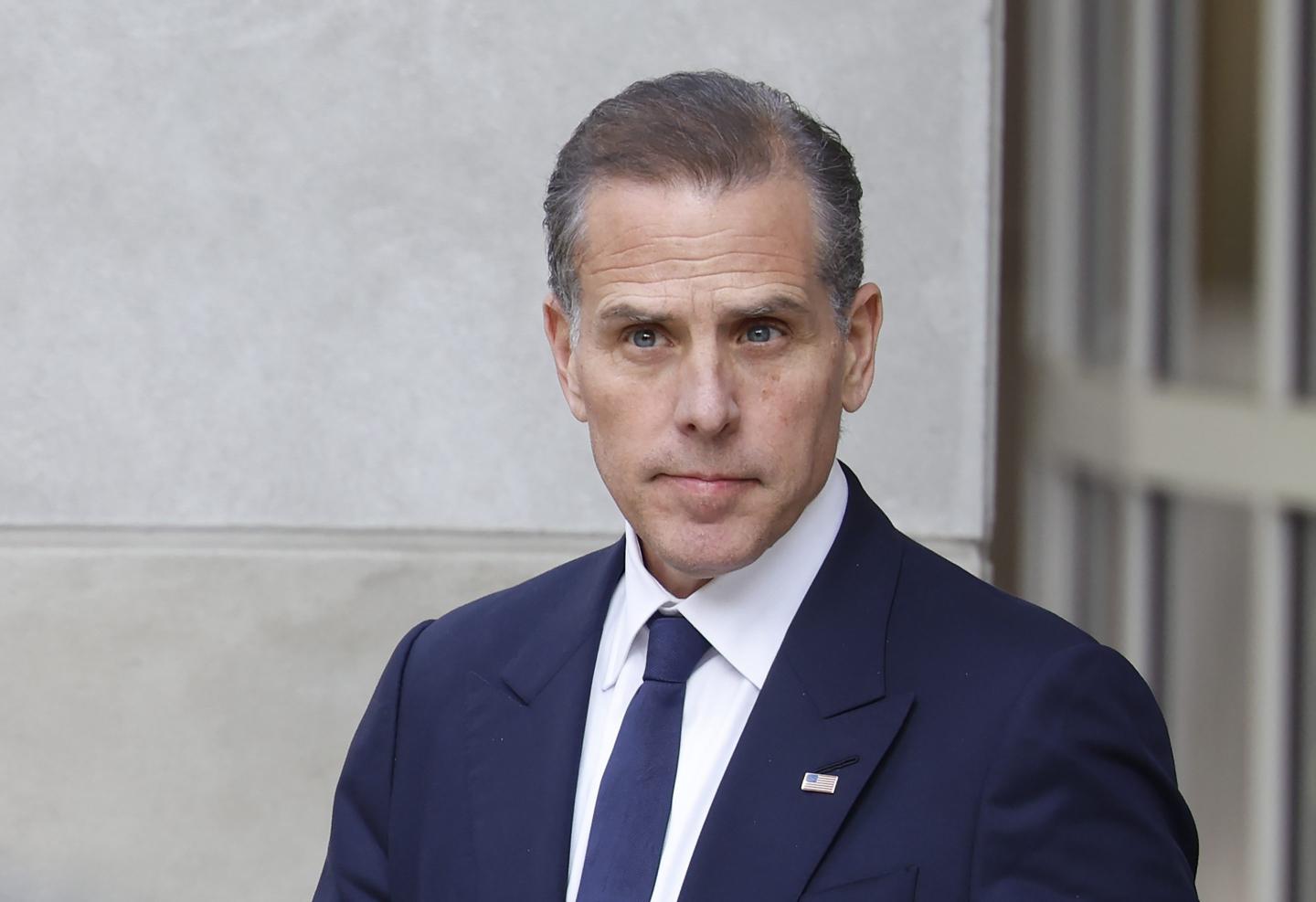 Hunter Biden wears a suit and gazes off into the distance.