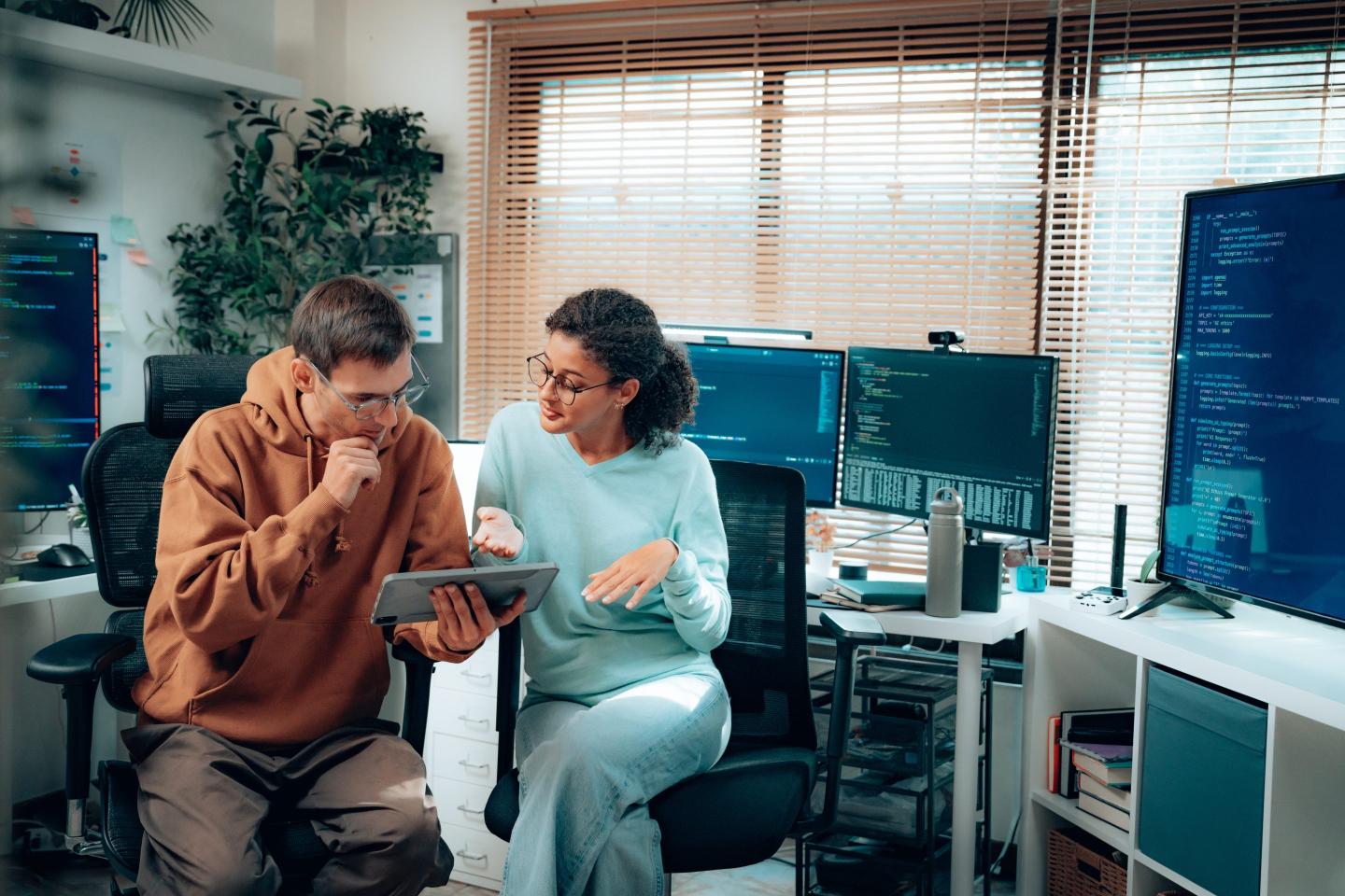 Latina software developer reviewing code with colleague in office