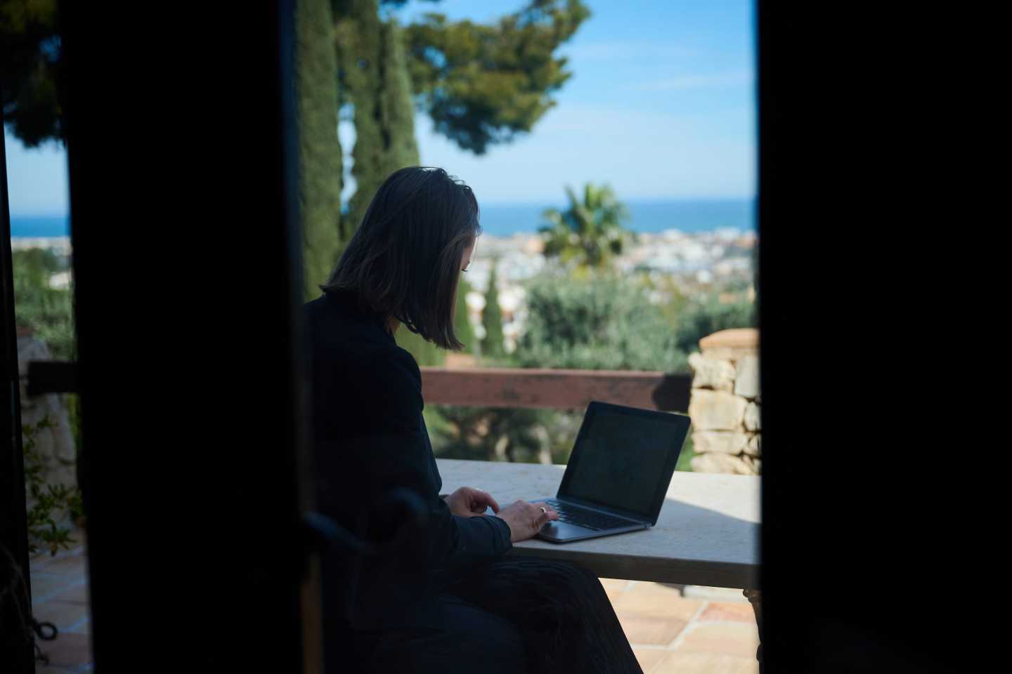 Photo of woman sitting at her laptop with a view of Spain