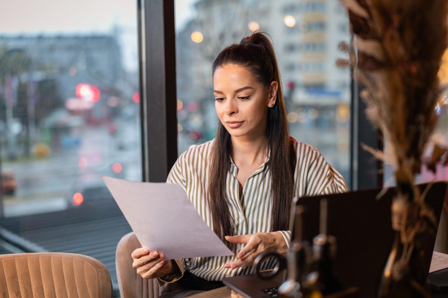 A person at a desk looking over a form.