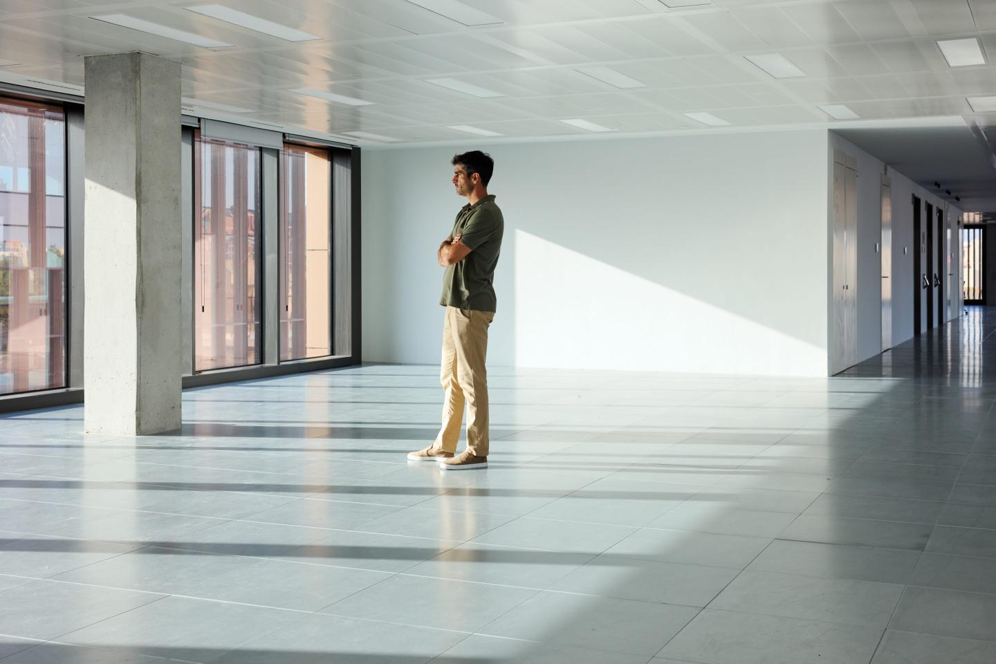 A person standing in an empty office space.