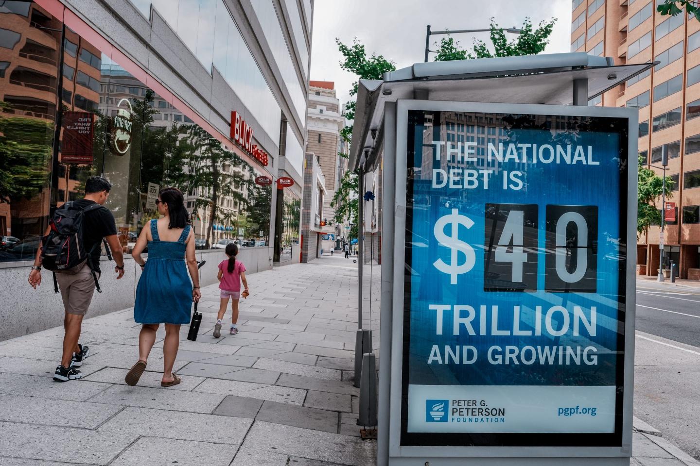 A view of a bus shelter at 13th and I St's NW where an electronic billboard and a poster display the current U.S. National debt per person and as a nation at 40 Trillion Dollars on August 30, 2026 in Washington, DC.