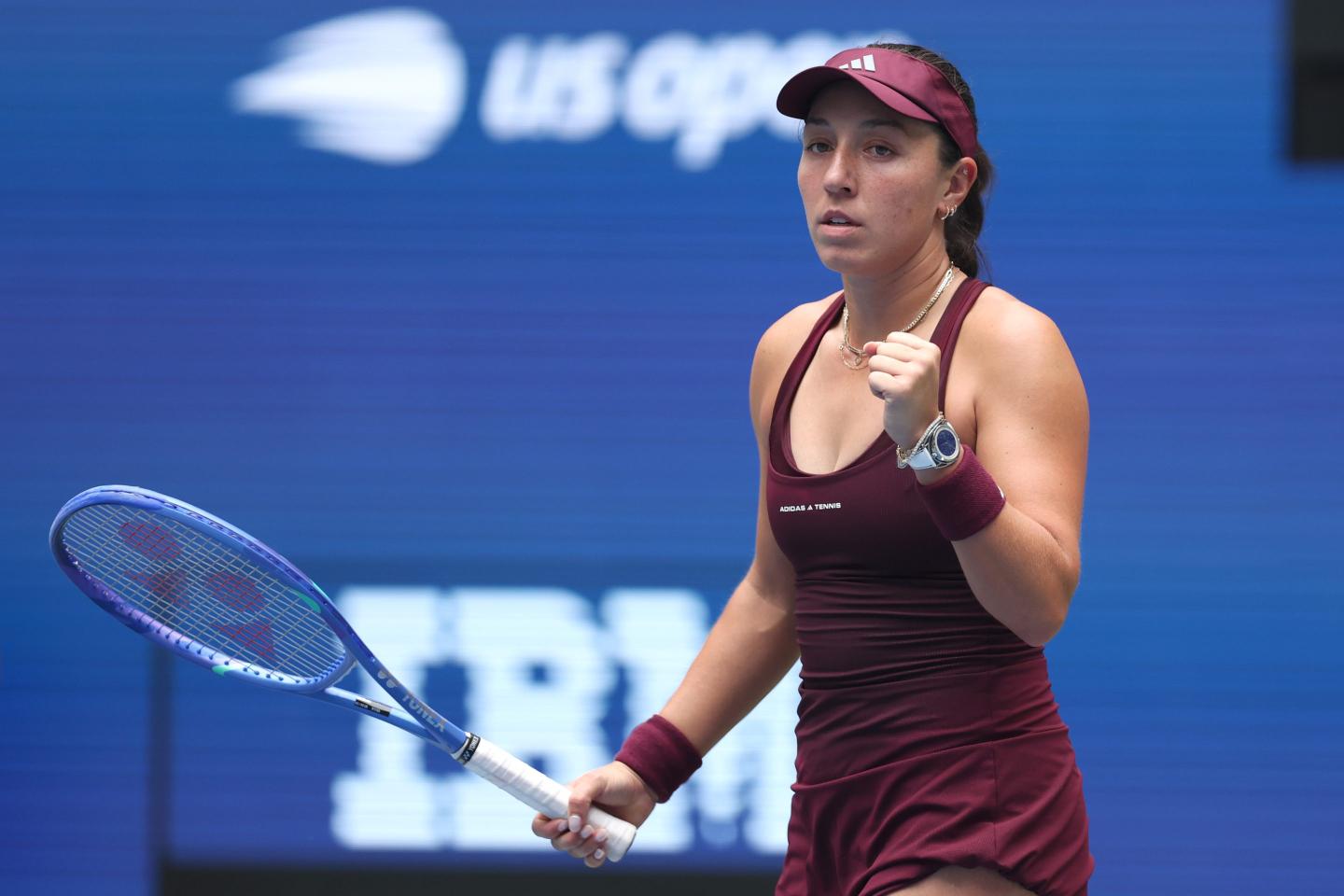 Jessica Pegula with a clutched fist and a tennis racket.