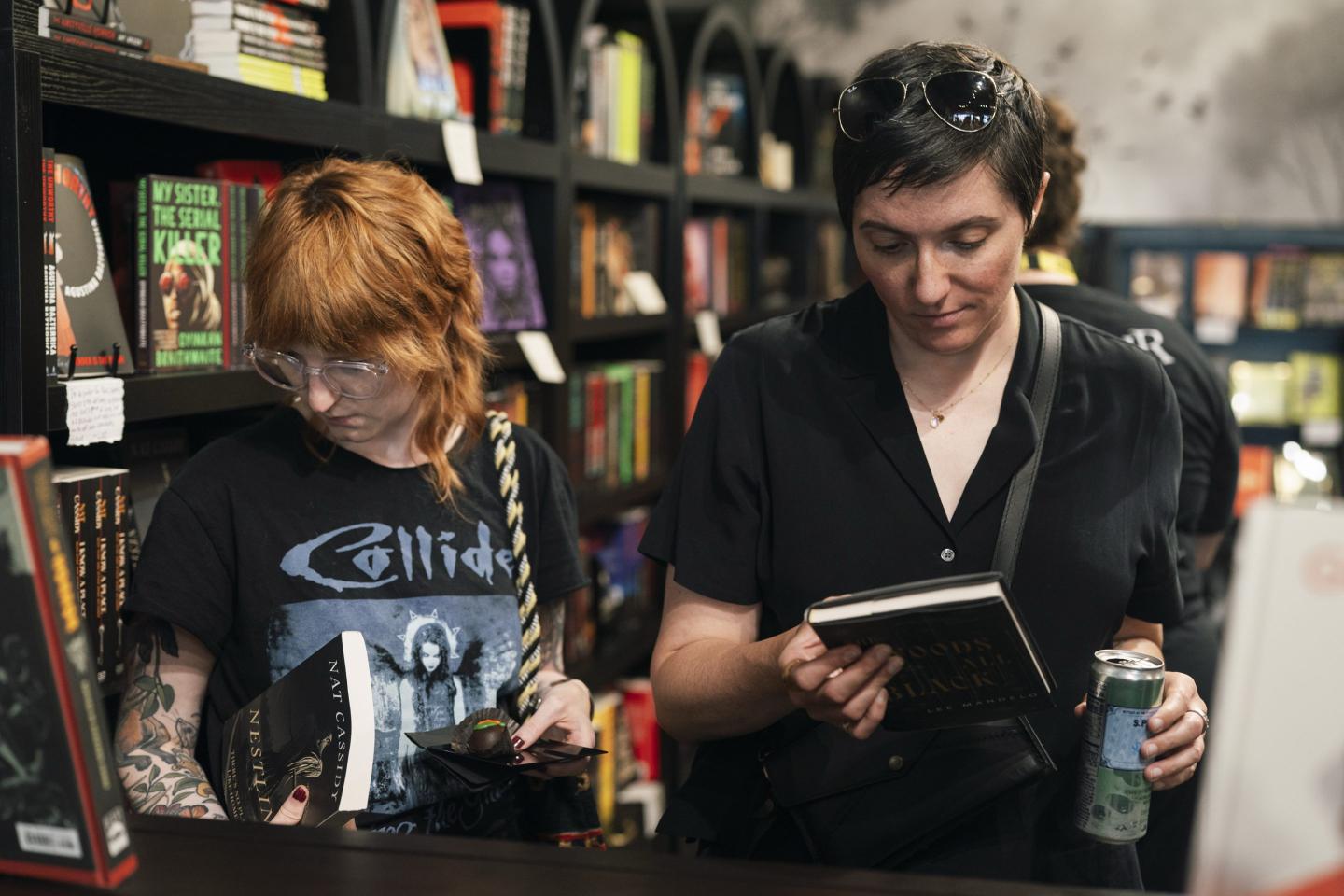 Two people browse books in a bookstore.