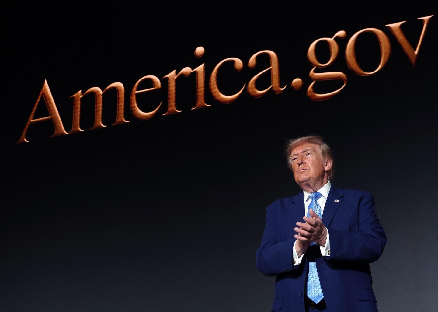 President Donald Trump applauds on stage during the America.gov launch event at Andrew W. Mellon Auditorium on September 29, 2026 in Washington, DC. The website features an artificial intelligence tool to help Americans interact with the federal government.