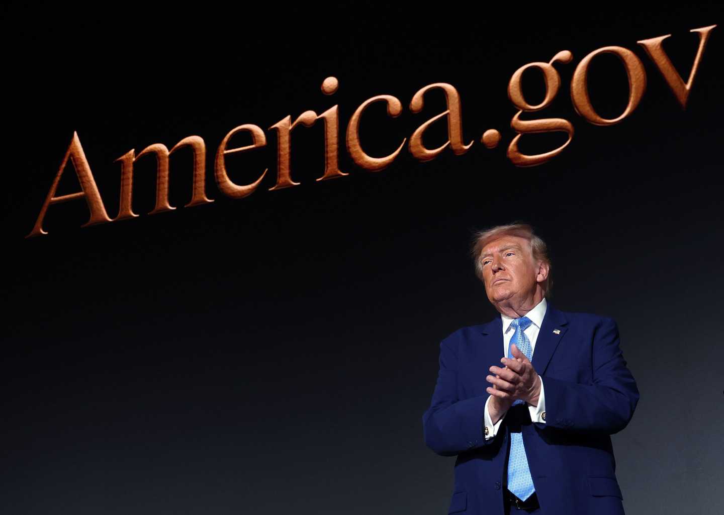President Donald Trump applauds on stage during the America.gov launch event at Andrew W. Mellon Auditorium on September 29, 2026 in Washington, DC. The website features an artificial intelligence tool to help Americans interact with the federal government.