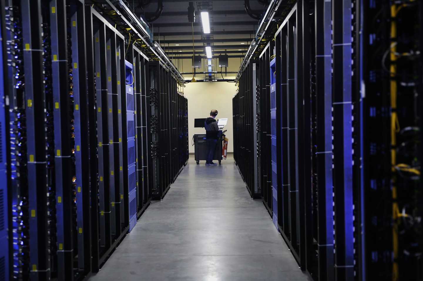 An employee fixes part of a web server inside the Facebook Inc. Prineville Data Center in Prineville, Oregon, U.S.