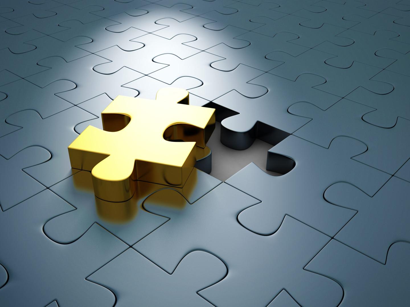 A jigsaw puzzle with one golden piece outside of the rest.