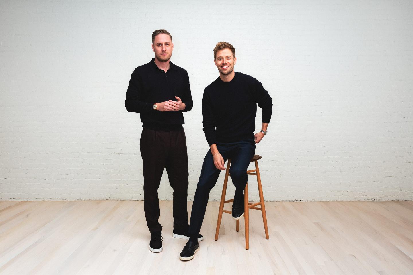 Public cofounder Leif Abraham (left) stands smiling at camera while Jannick Malling (right) does the same while sitting on a high stool.