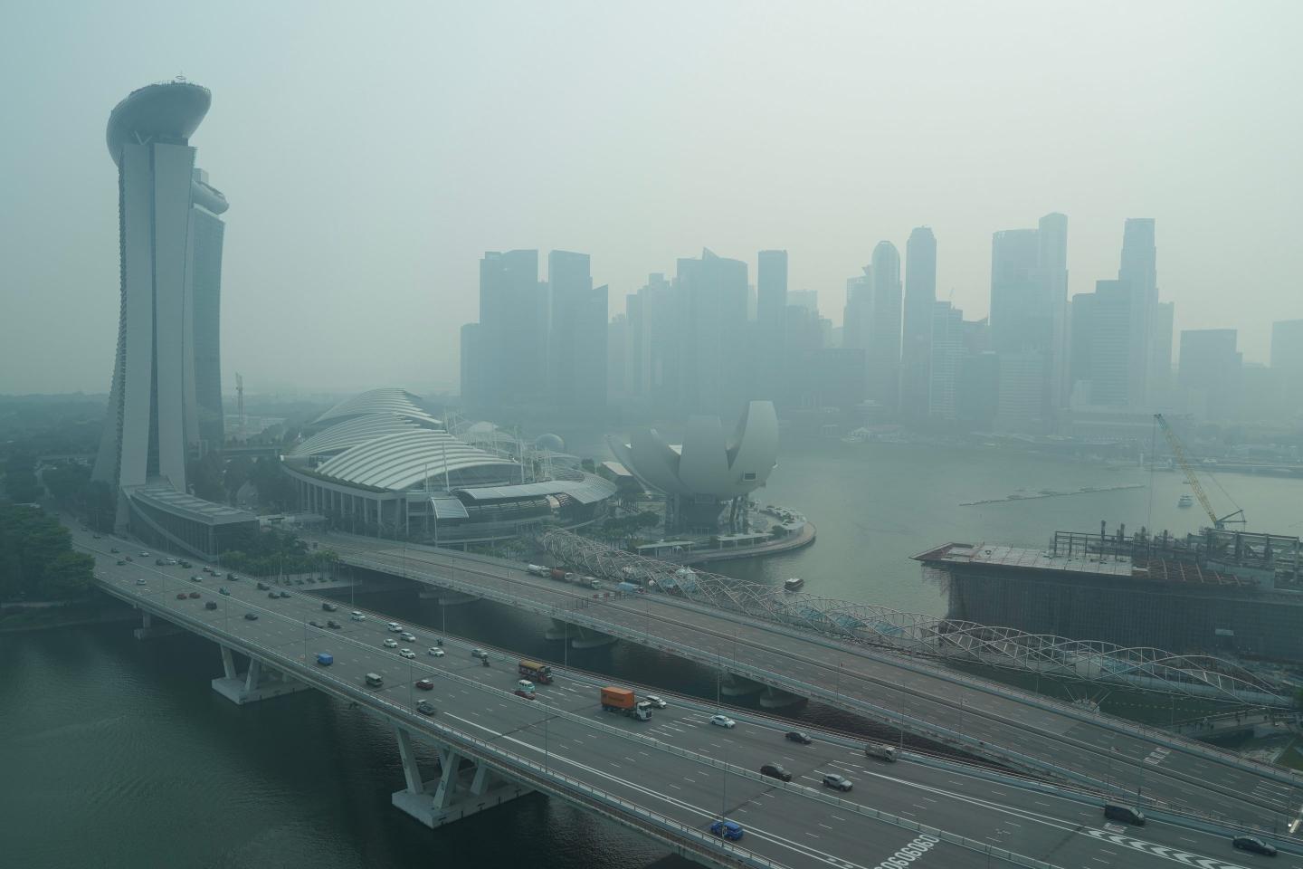 A thick haze obscures the skyline behind the Central Business District area in Singapore.