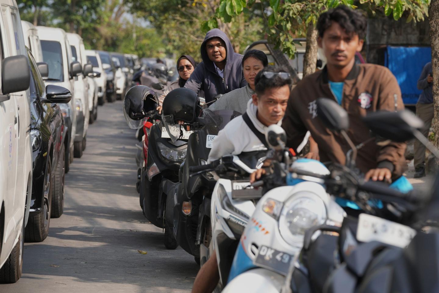 People queue at a gas station amid a fuel shortage in Denpasar, Bali, Indonesia
