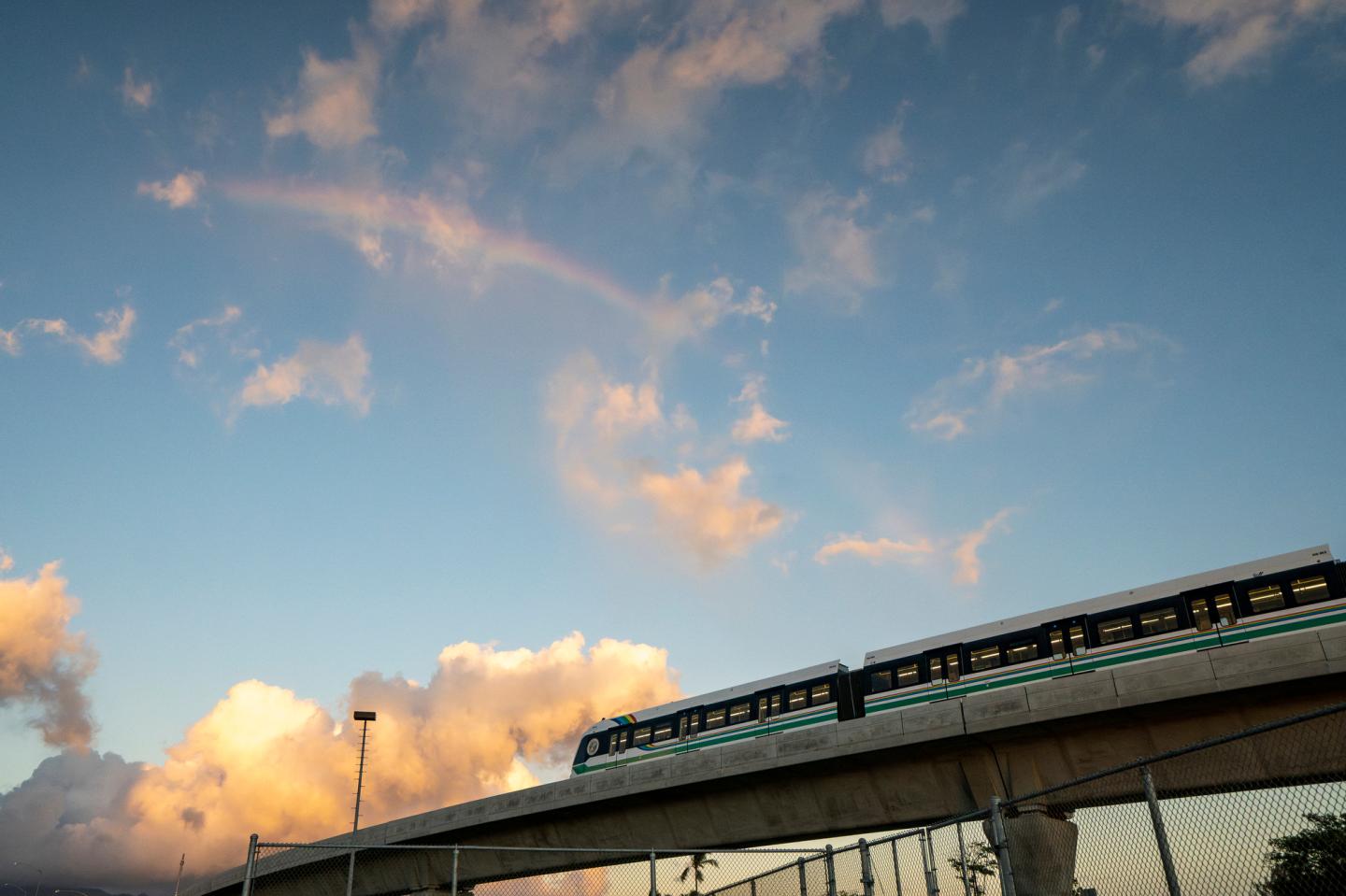 A rainbow arches over a Honolulu Skyline train at sunset, Sept. 19, 2024, in Honolulu. 