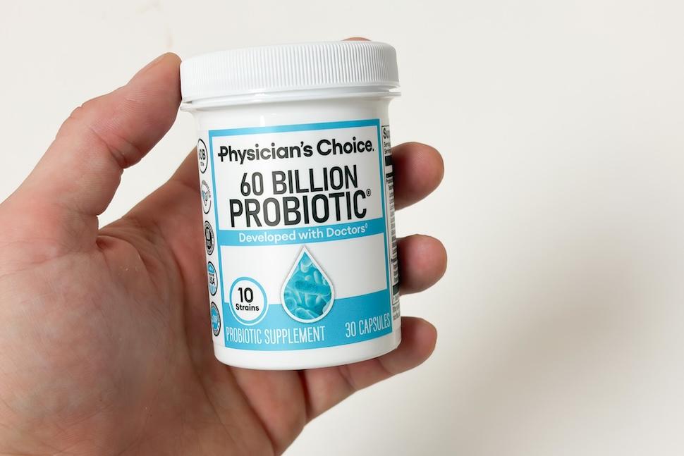 Closeup of a hand holding a bottle of Physician's Choice 60 Billion Probiotic