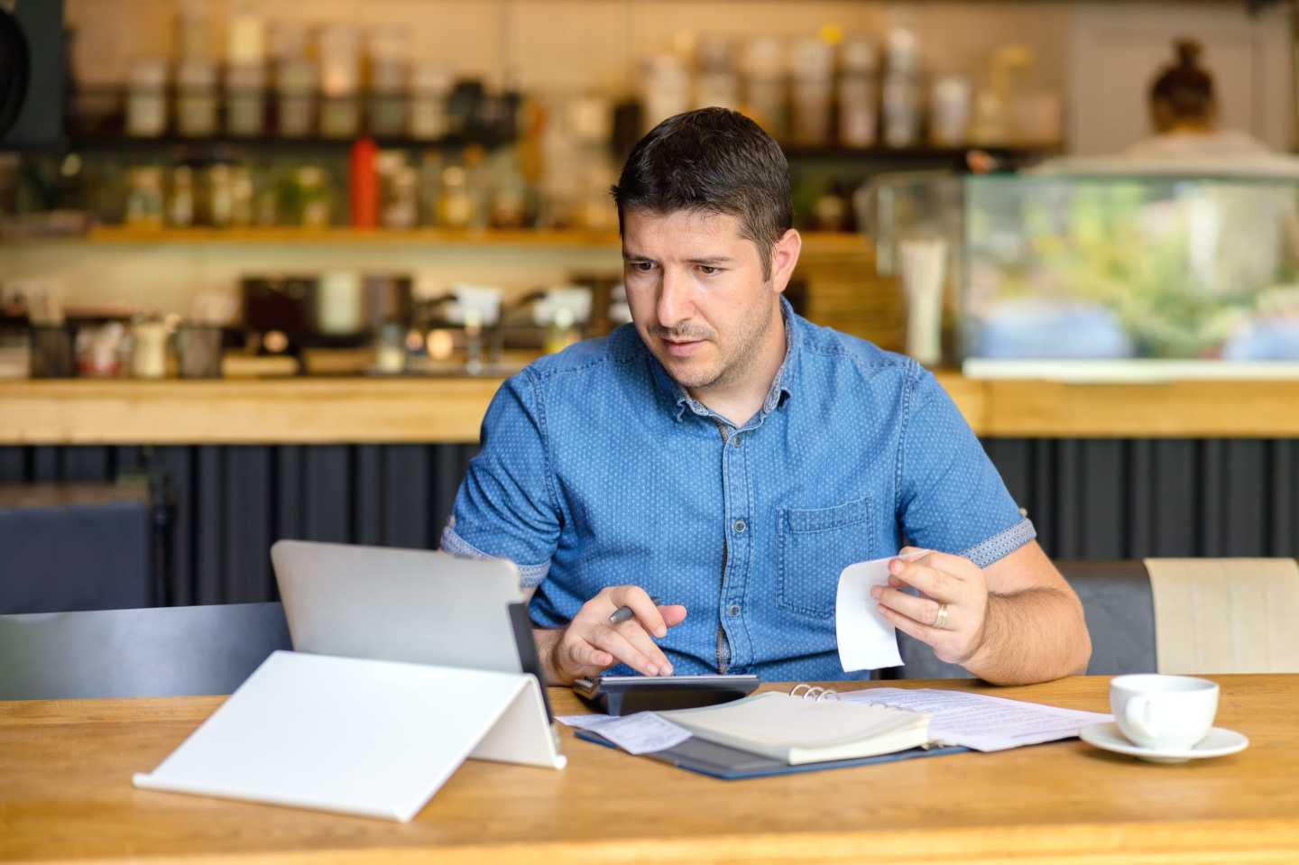 A person at a cafe working on their computer.