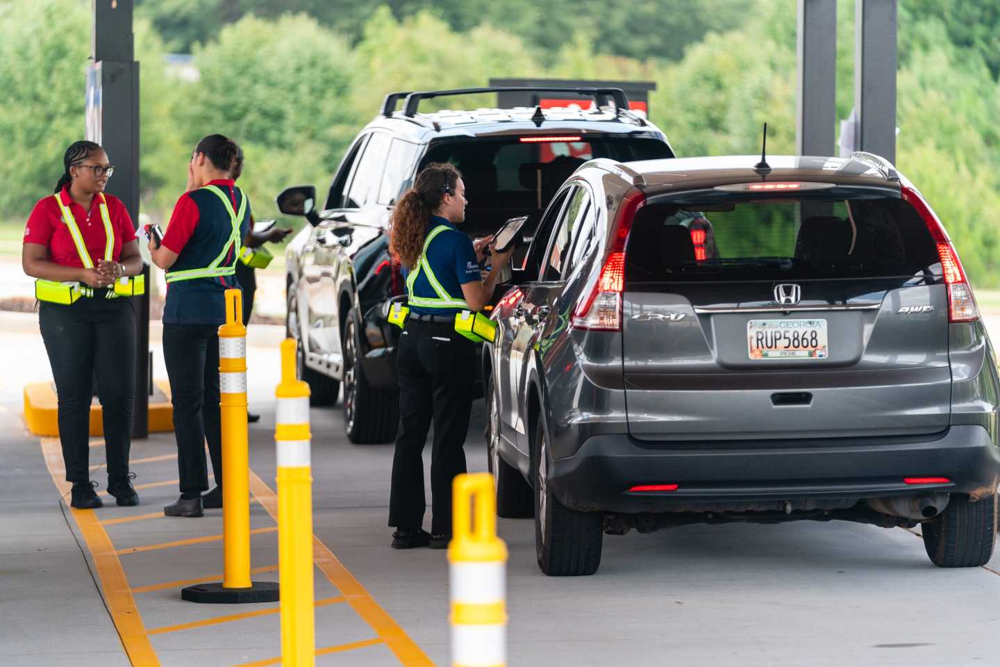 Chik-Fil-A team members take orders from customers in one of the two drive up to order lines on opening day at the company's first elevated sestaurant on August 22, 2024 in McDonough, Georgia.