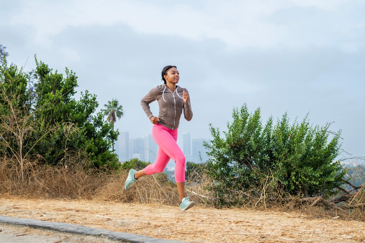 Young woman running along rural road