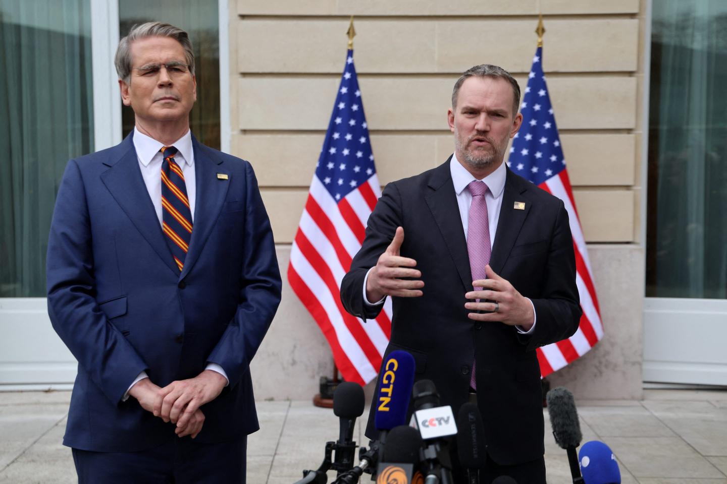 Jamieson Greer (right) speaks in front of a cluster of microphones and Scott Bessent stands beside him.