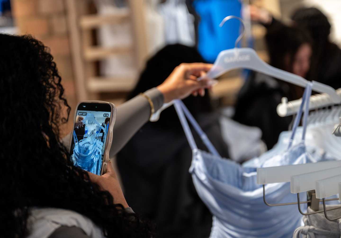 Photo of young woman snapping a photo of a dress