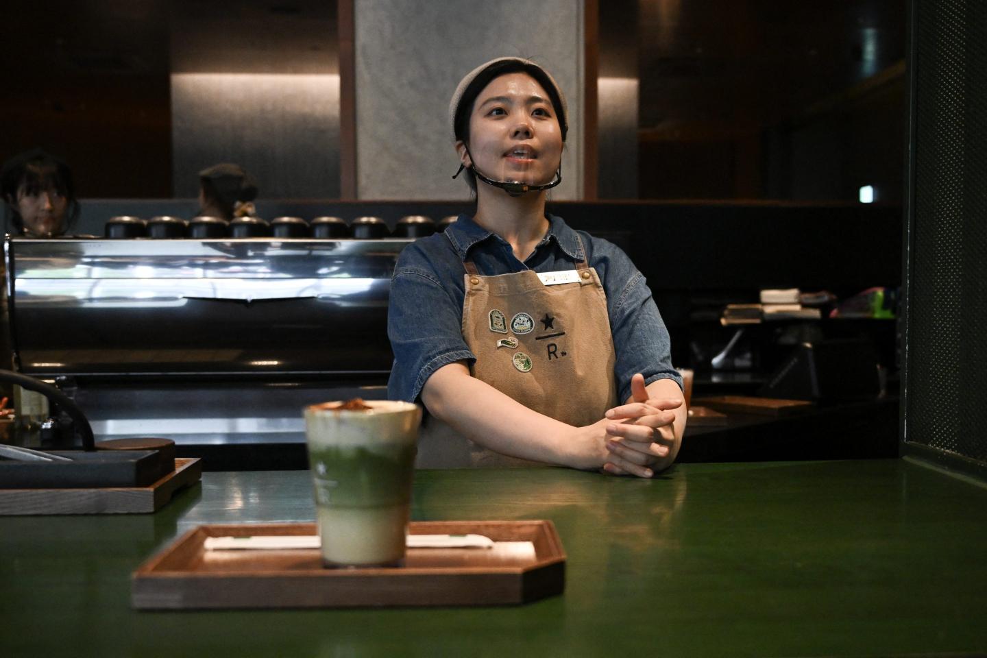 An employee stands behind a counter at a Starbucks coffee shop in Seoul on May 19, 2026.