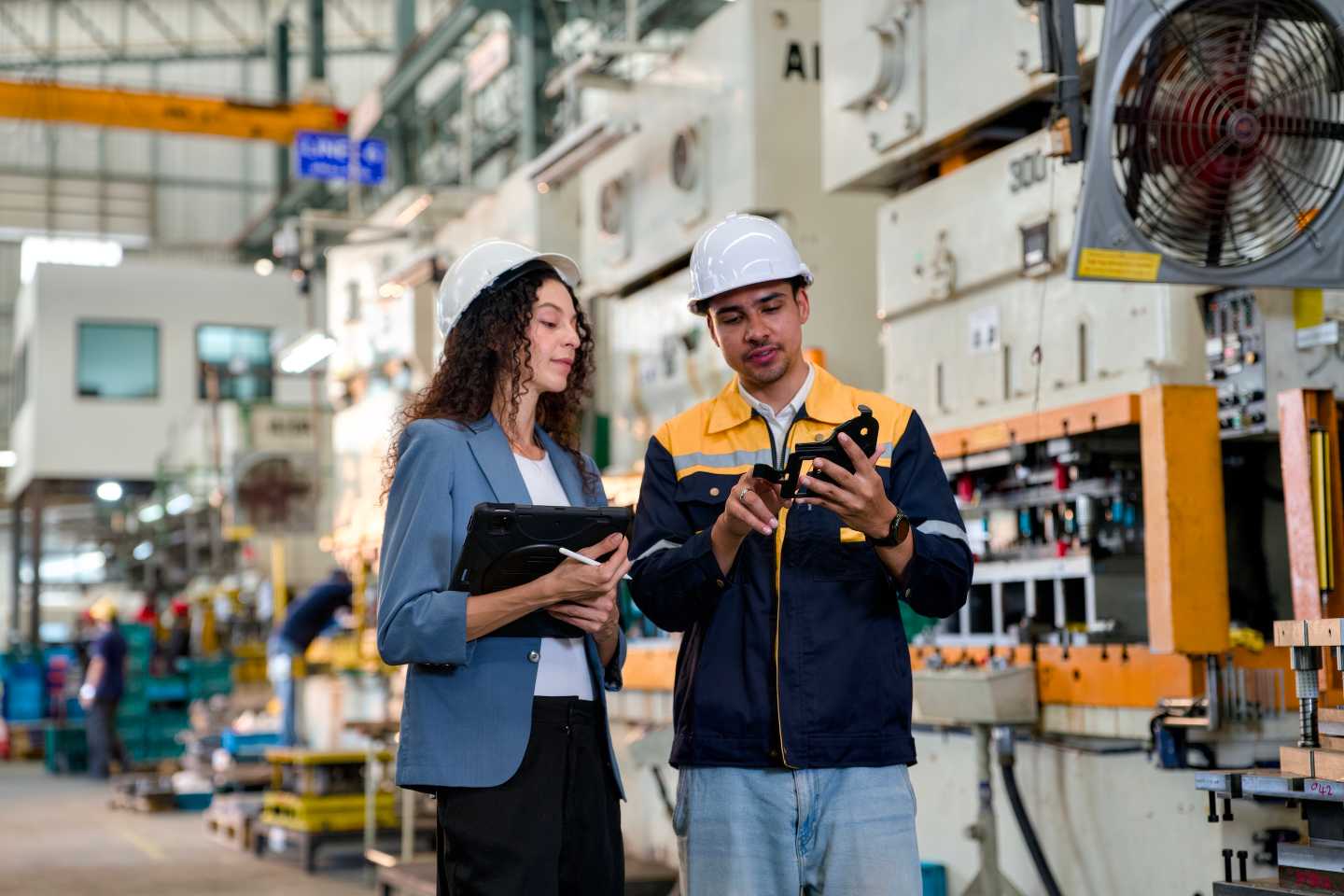 Executive and engineer discussing manufacturing in a modern factory