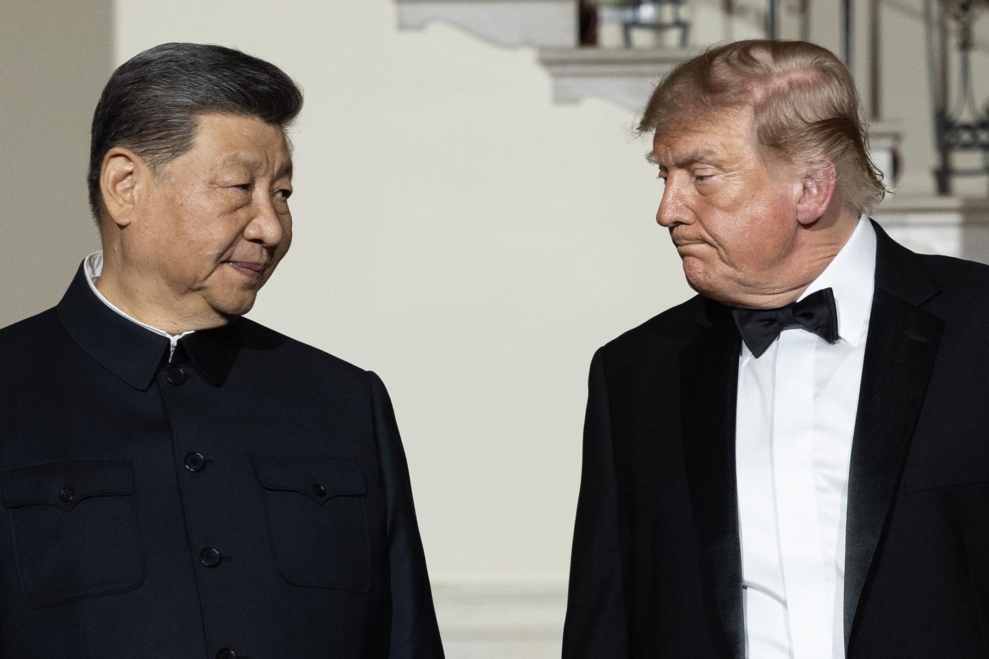 Chinese President Xi Jinping (L) looks to U.S. President Donald Trump as they descend the grand staircase before a state dinner in the East Room of the White House on September 24, 2026 in Washington, DC.