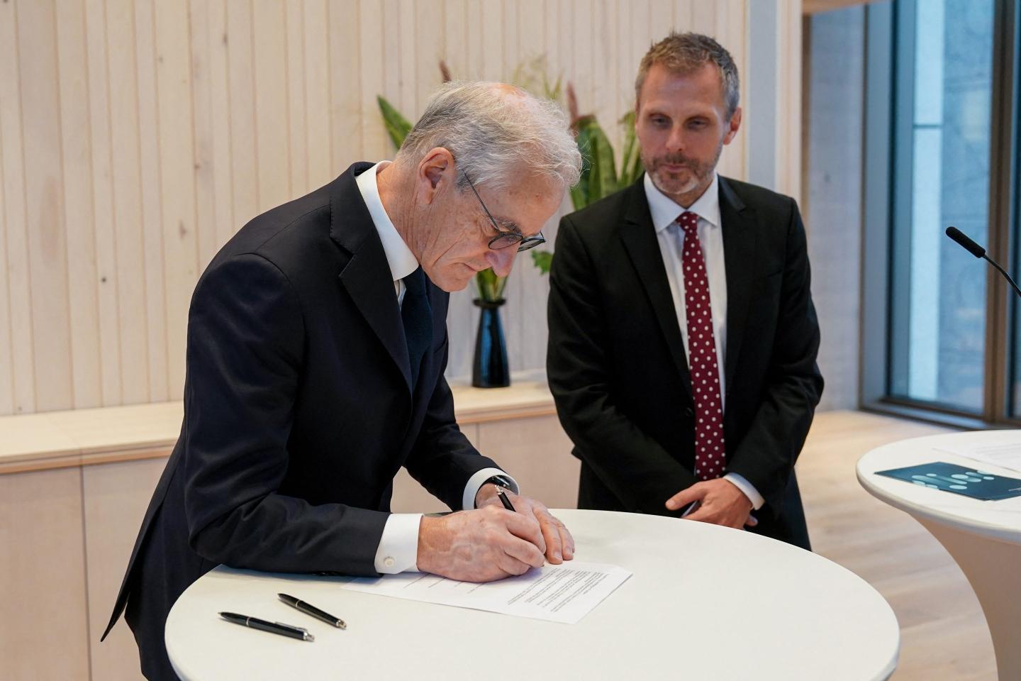 Norway's Prime Minister Jonas Gahr Støre (L) and Norway's Minister of Digitalisation and Public Administration Torgeir Micaelsen sign a letter of intent on the responsible introduction and use of artificial intelligence in the workplace, in Oslo, Norway.