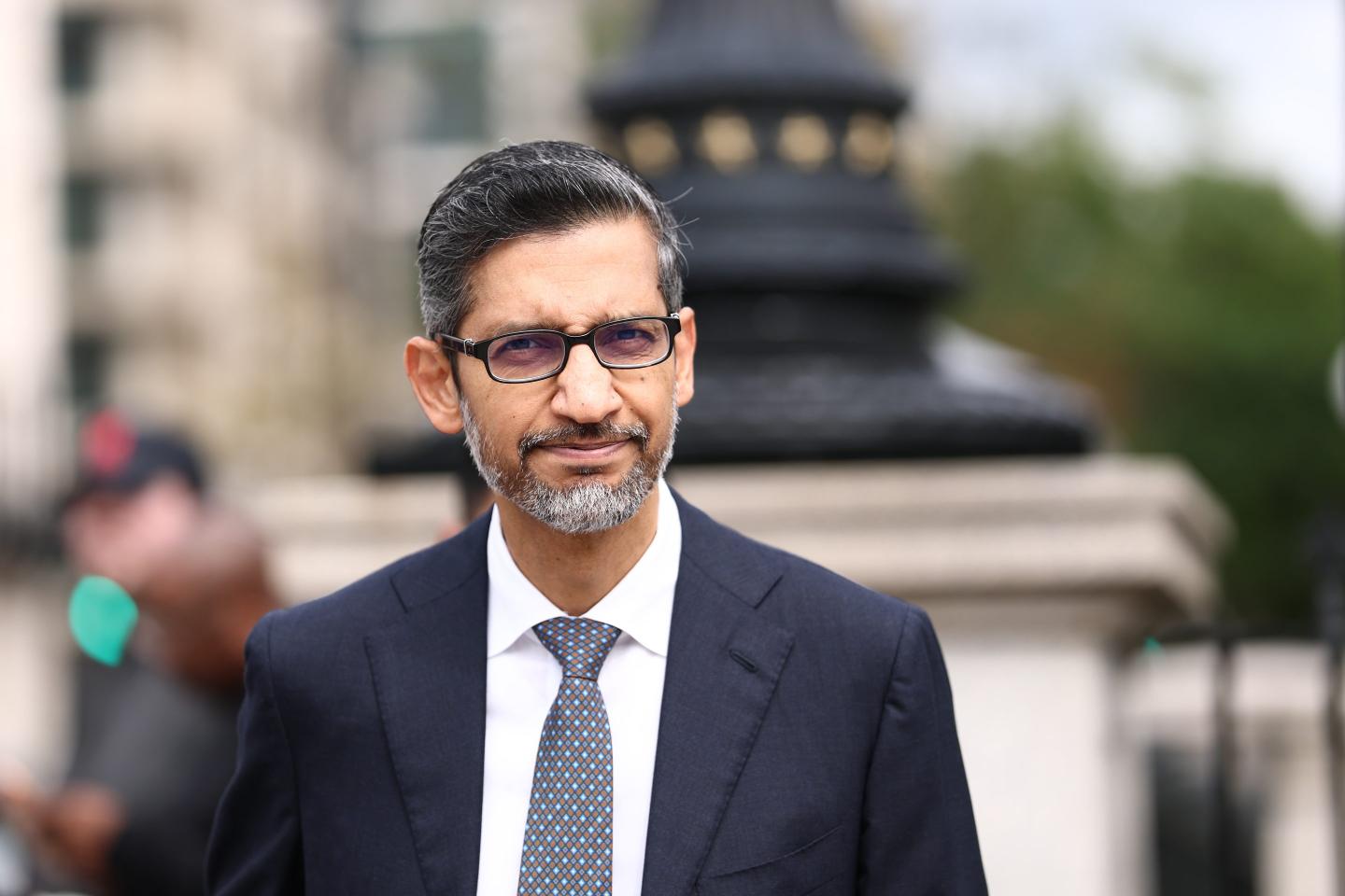 Man in a suit and glasses squints
