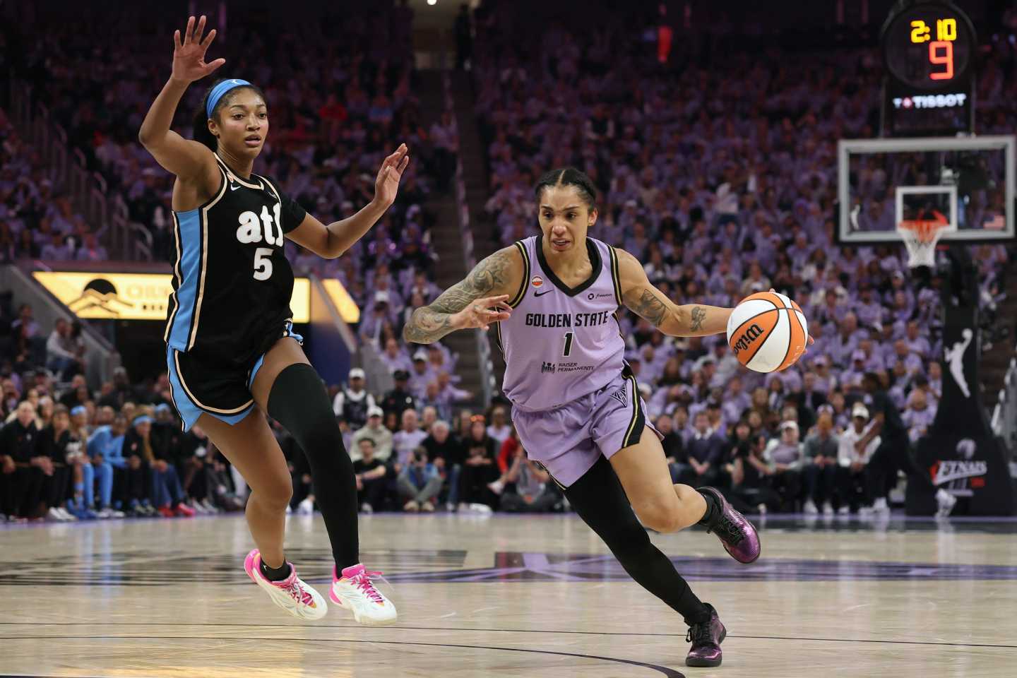 Gabby Williams dribbles the basketball down the court as Angel Reese tries to defend.