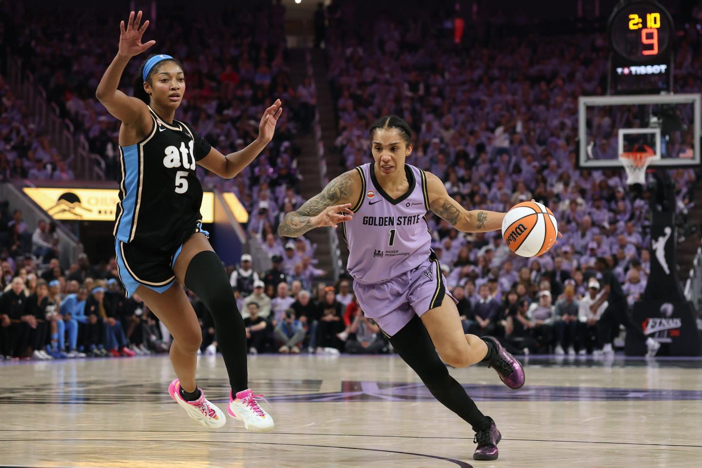 Gabby Williams dribbles the basketball down the court as Angel Reese tries to defend.