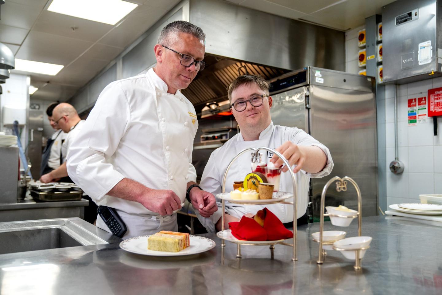 A chef at one of Hilton's hotels works with a junior member of staff