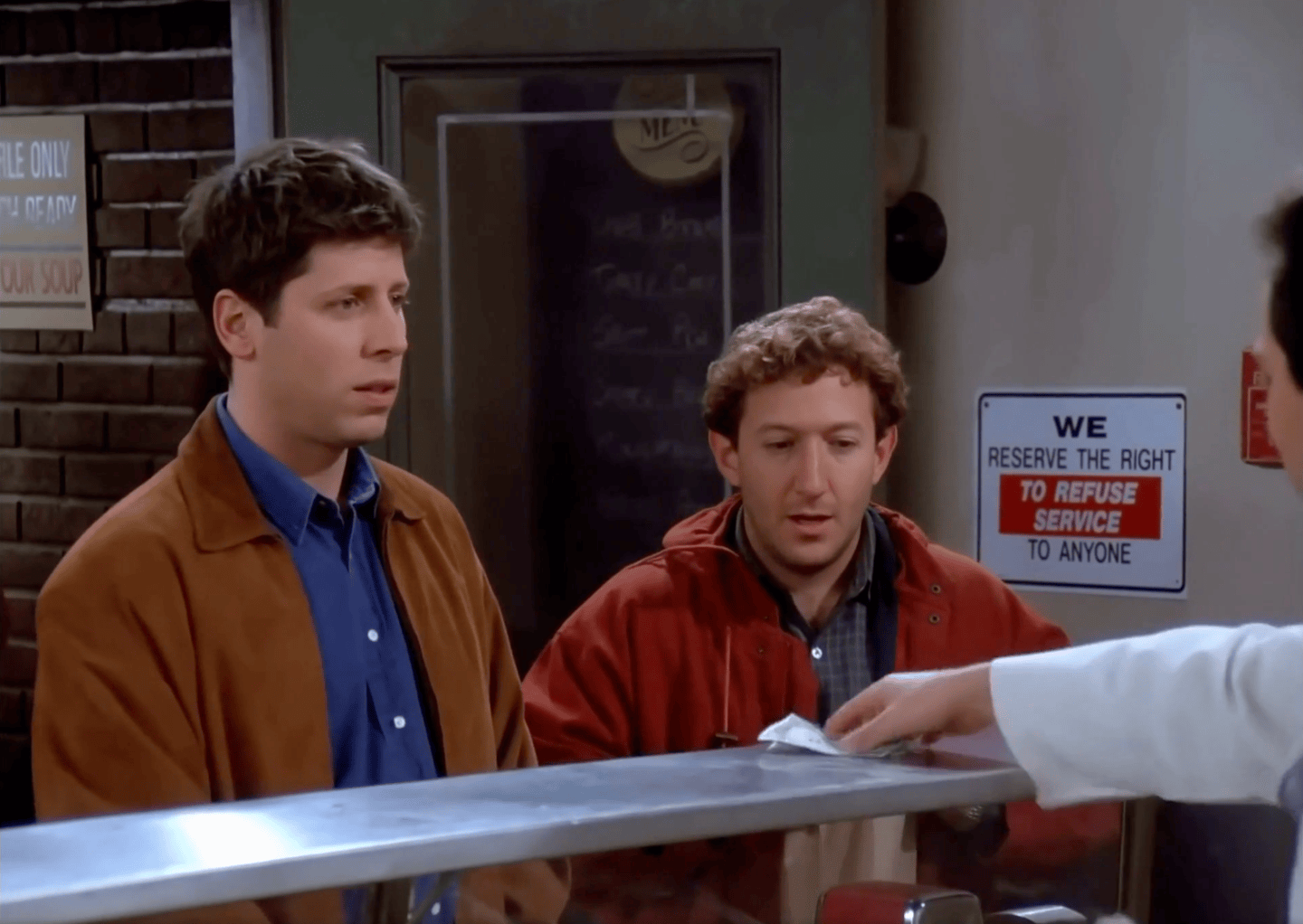 A still from an AI-generated video superimposing OpenAI CEO Sam Altman and Meta CEO Mark Zuckerberg on a scene from the TV series Seinfeld.