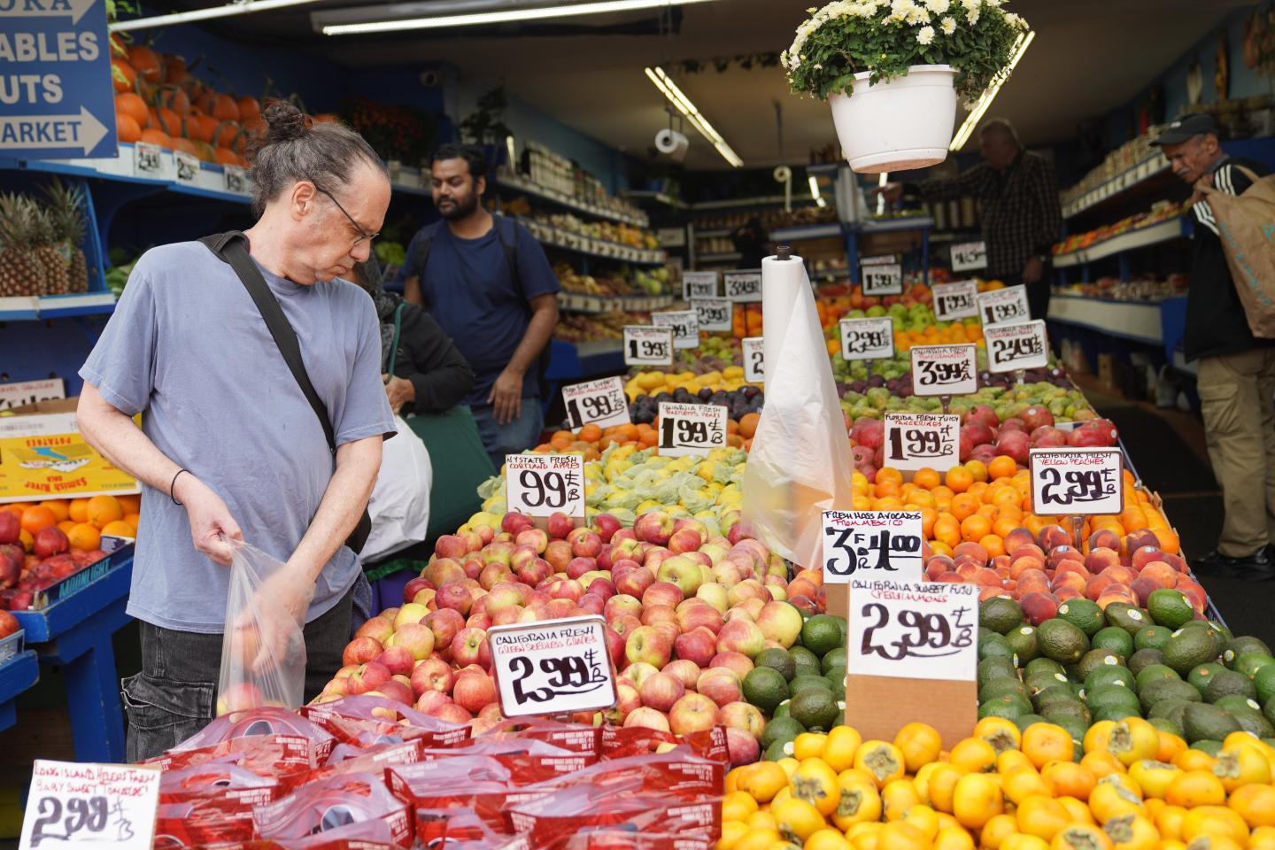 A man picks fruit at a store in New York
